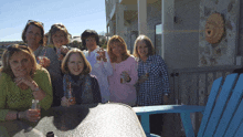 a group of women are posing for a picture while holding drinks