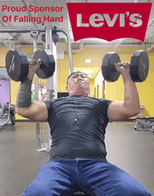 a man is lifting dumbbells in a gym with a levi 's logo in the background