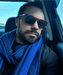 a man wearing sunglasses and a blue scarf