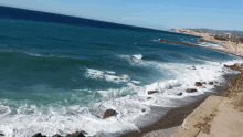 a large body of water with waves crashing on a rocky shore