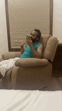 a man sitting in a recliner looking at his phone