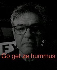 a black and white photo of a man with the words go get ze hummus on the bottom