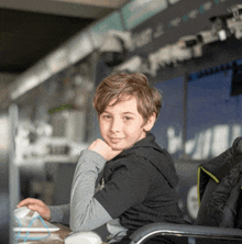 a young boy is sitting at a desk with a computer mouse in front of him