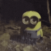 a yellow minion with big eyes is sitting in the rain .