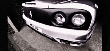 a black and white photo of a ferrari with a license plate that says nt53 bb