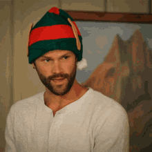 a man with a beard wears a santa hat
