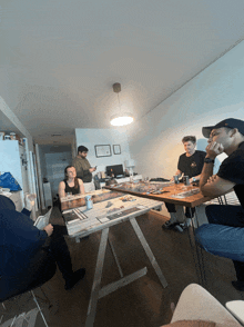 a group of people are sitting around a table with a can of beer on it