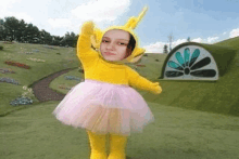 a girl in a yellow teletubbies outfit with a pink tutu