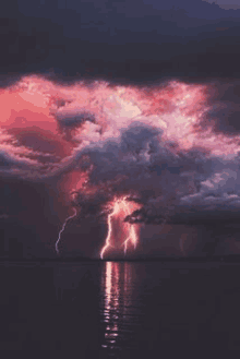 a lightning storm over a body of water with a purple sky