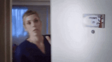 a woman is standing in front of a door with a sticker on it that says ' mono '