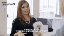 a woman is holding a small white dog and says i never like it when someone feels left out