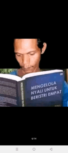 a man is reading a book titled menglola nyali untuk beristri empat