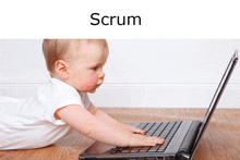 a baby is playing with a laptop computer and the word scrum is above him