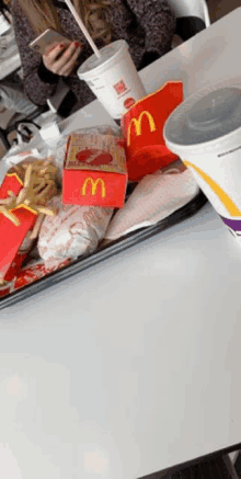 a woman sits at a table with a tray of mcdonalds food