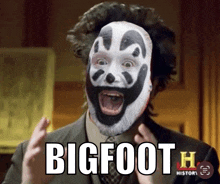 a man in a suit and tie with a clown mask on his face says bigfoot