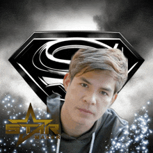 a man stands in front of a superman logo and the word star