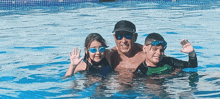 a man and two children in a swimming pool waving