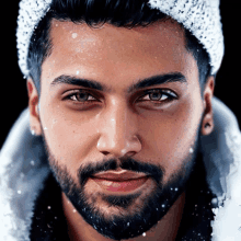 a close up of a man 's face with snow falling on his head