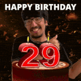 a man is giving a thumbs up in front of a birthday cake with the number 29 on it