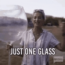 a woman is holding a very large glass of water in her hand .