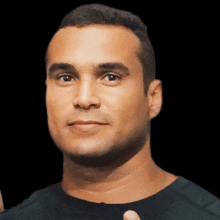 a man in a black shirt is giving a thumbs up sign .