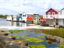 a row of colorful houses sit on stilts over a body of water