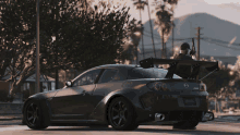 a man holding a gun is standing next to a mazda rx8