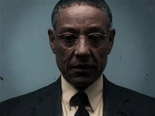 a man in a suit and tie is wearing glasses .