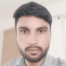 a man with a beard and mustache is taking a selfie in a room .