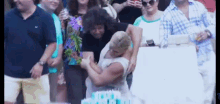 a group of people are standing around a table with a cake that says ' i love you ' on it .