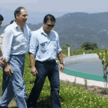 a group of men are walking in a field with a pool in the background