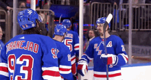 a group of hockey players are standing on the ice and one of them has the number 93 on his jersey .