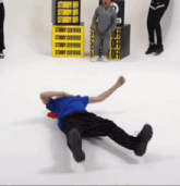 a man is laying on the floor in front of a yellow sign that says sturdy off
