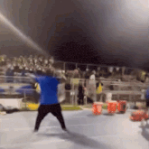 a man in a blue shirt is throwing a frisbee at a crowd