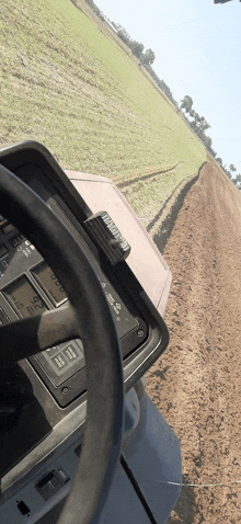 a yamaha tractor is plowing a field and the steering wheel is shown in the foreground