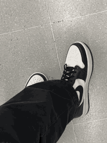 a person wearing black and white nike shoes