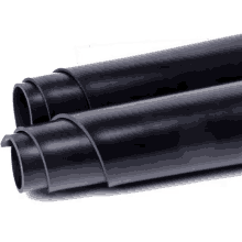 a close up of two black rubber tubes stacked on top of each other on a white surface .