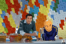 a man and a cartoon character are sitting at a table