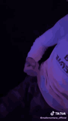 a tiktok video of a person wearing a white shirt with a purple background