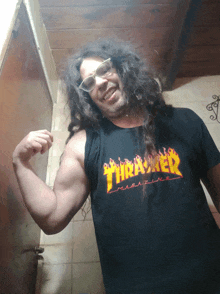 a man wearing a thrasher magazine tank top flexes his muscles