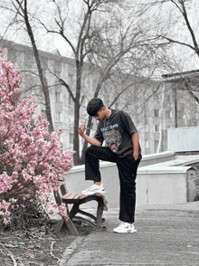 a young man wearing a t-shirt that says tarot king is sitting on a bench