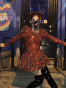 a woman wearing a mask stands in front of a sign that says " loud partner ways "