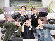 a group of young men are making hearts with their hands in front of a banner that says nov.