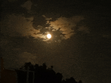 a full moon shines through the clouds in a dark night sky