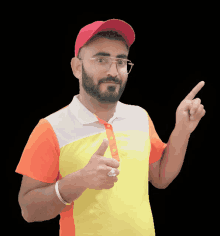 a man wearing a red hat and glasses is pointing upwards
