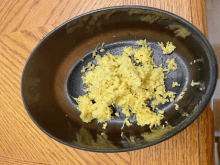 a black bowl filled with ginger is on a wooden table