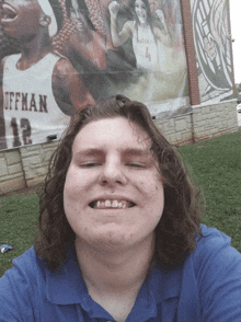 a young man taking a selfie in front of a billboard that says offman