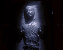 a statue of a man in a dark room with his hands outstretched