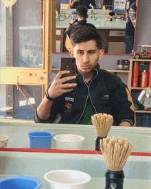 a man taking a picture of himself in a barber shop with a sign that says " sadece erkek "