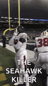 a football player is standing on the field with the words `` the seahawk killer '' written on the bottom .